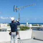 沖縄の住宅の屋上でテレビアンテナを設置する作業